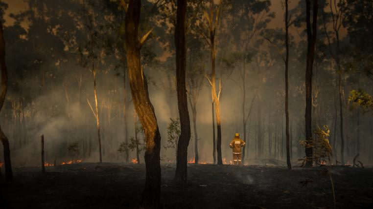 Australischer Feuerwehrmann im abgebrannten Wald