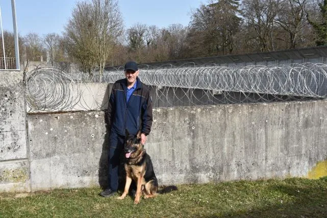 67f08b9cb50bb750af1a72531b570058eb57a966 Jürg Berger mit Schäferhund Dusty vor den Gittern der Justizvollzugsanstalt Pöschwies in Regensdorf.
